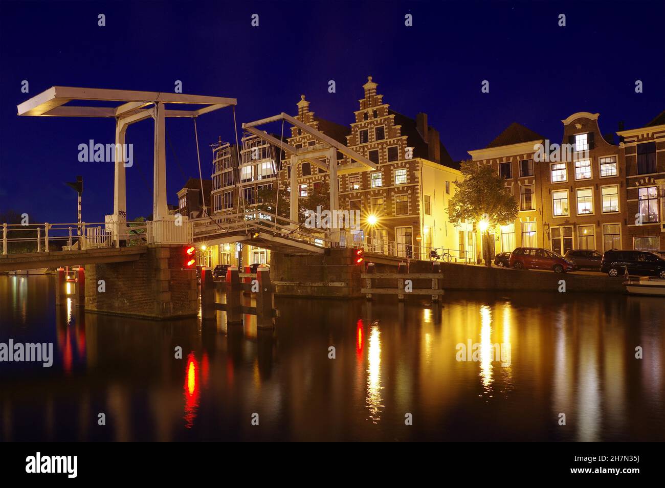 Canal, old bascule bridge and buildings along a waterfront, blue hour, Haarlem, North Holland, Netherlands Stock Photo