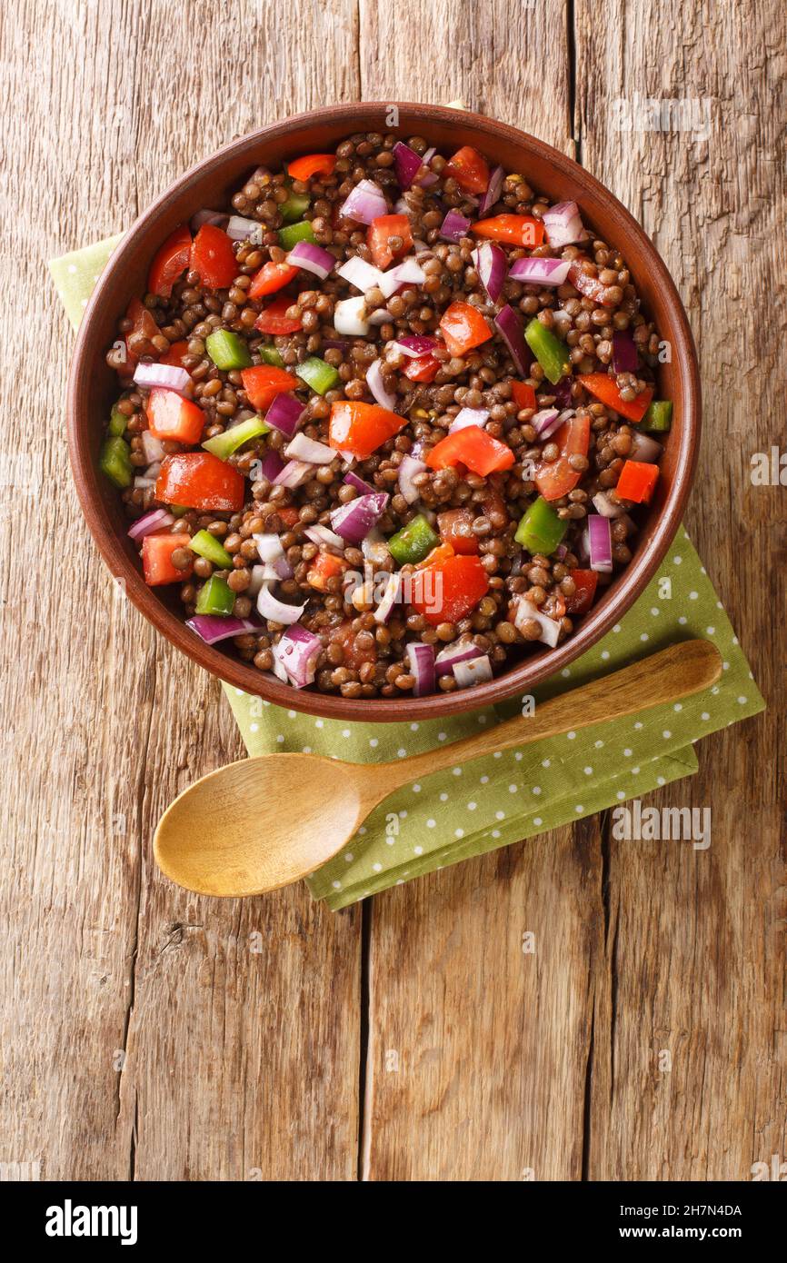 Azifa is an Ethiopian green lentil dish with lime juice, tomato, mild hot peppers, onion and spices close up in the plate on the table. Vertical top v Stock Photo