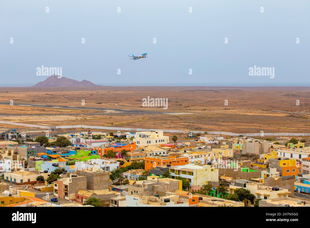 Plane takes off, in front colourful houses of Espargos, Sal Airport ...