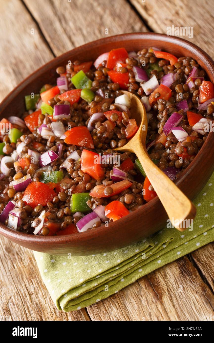 Azifa is an Ethiopian green lentil dish with lime juice, tomato, mild hot peppers, onion and spices close up in the plate on the table. Vertical Stock Photo