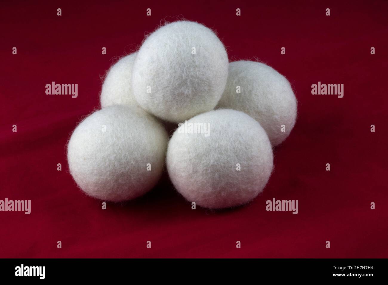 Stack of wool tumble dryer balls on a red background Stock Photo Alamy