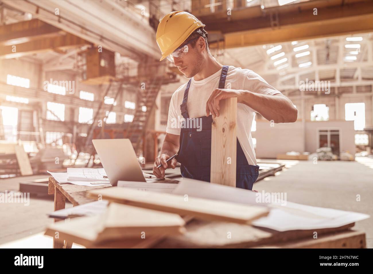 Handsome man builder using notebook at construction site Stock Photo