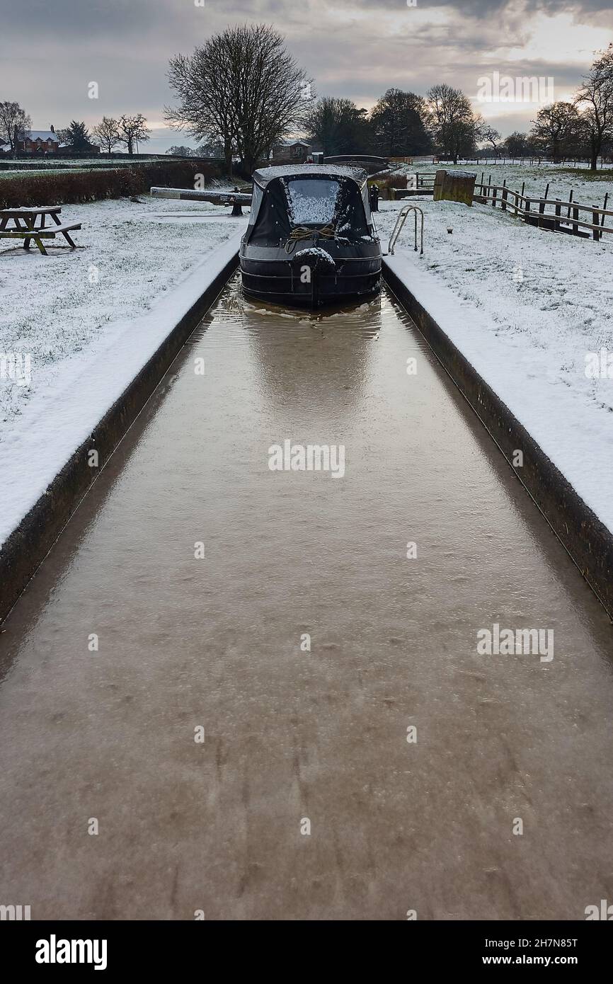 Narrowboat in a frozen lock in Cheshire on the Shropshire Union canal in winter Stock Photo