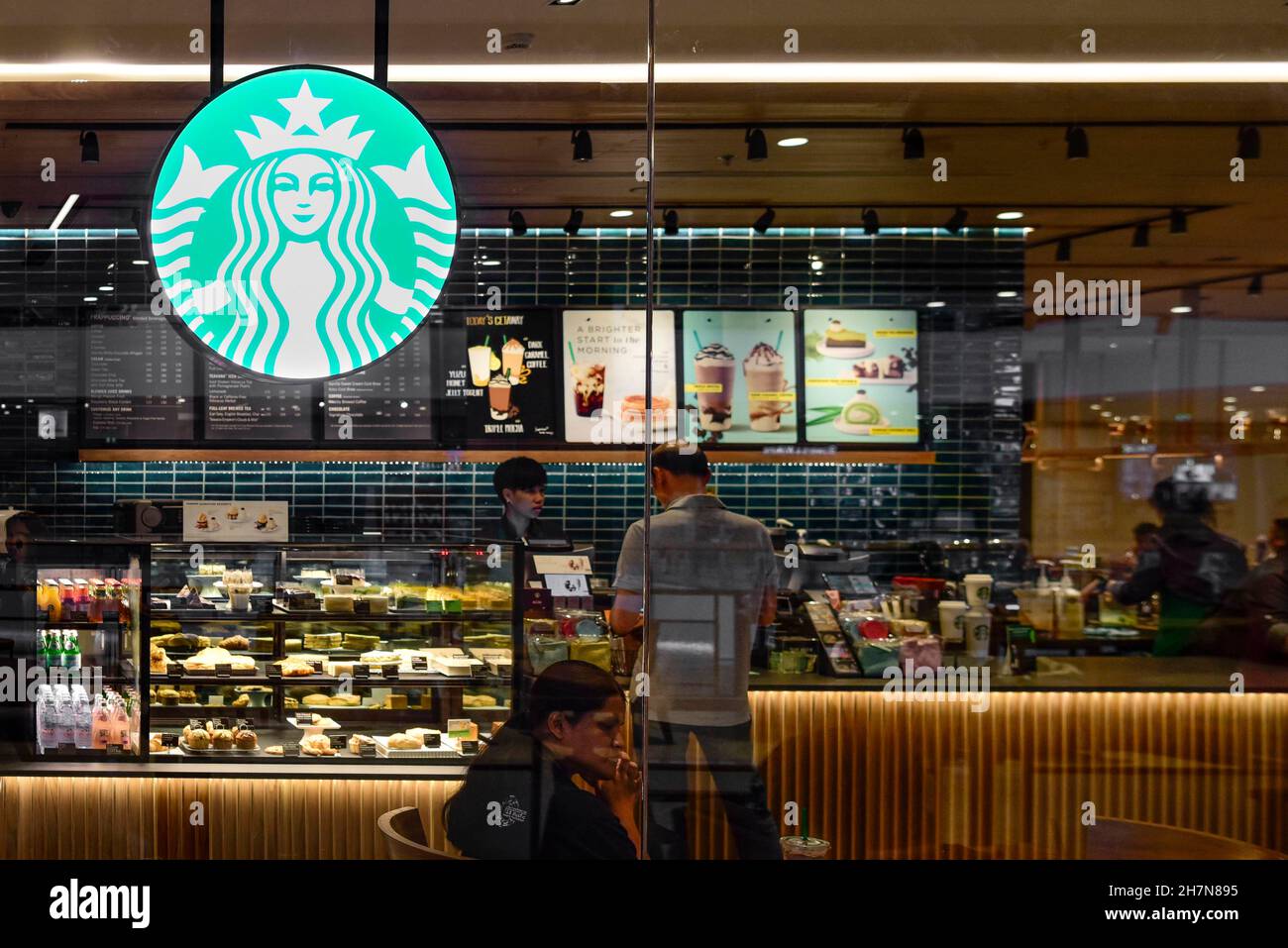 Starbucks shop window illuminated Stock Photo Alamy
