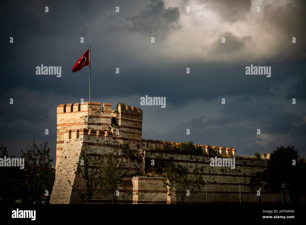 Turkish flag on fortress, turkish flag on top of the stone wall castle istanbul in night, medieval war history background concept Stock Photo