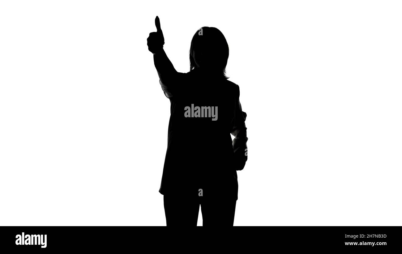 Photo of woman's silhouette in suit jacket with thumb gesture Stock Photo