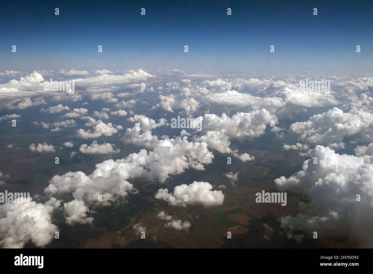 Aerial view from airplane window of white puffy clouds on bright sunny ...
