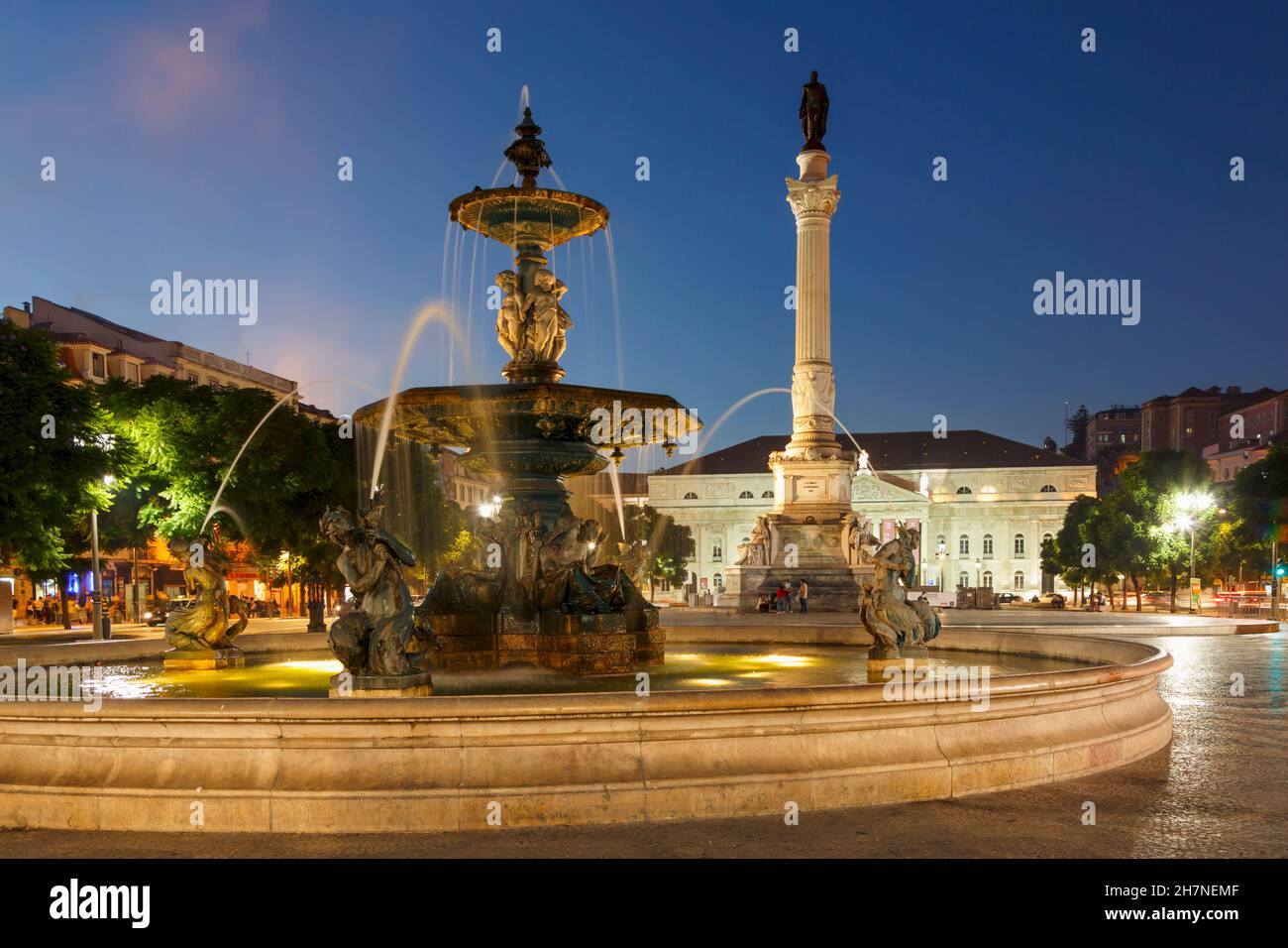 Lisbon, Portugal. Praca Dom Pedro IV, commonly known as Rossio.  Dusk.  The white building is the National Theatre, Teatro Nacional Dona Maria II.  Th Stock Photo