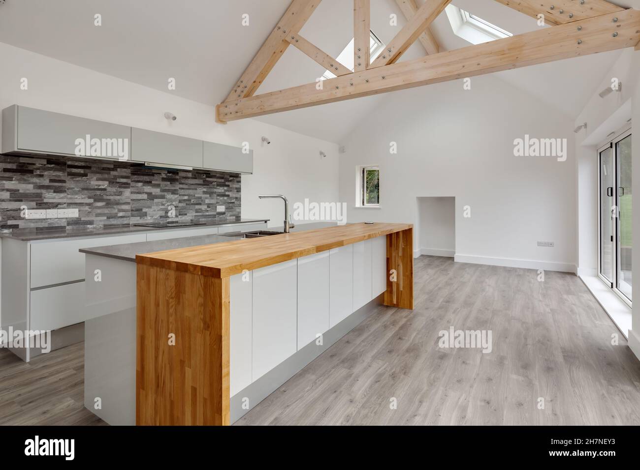 Lolworth, Cambridgeshire - July 30 2019: Brand new unoccupied home kitchen with vaulted ceiling and island peninsula unit Stock Photo