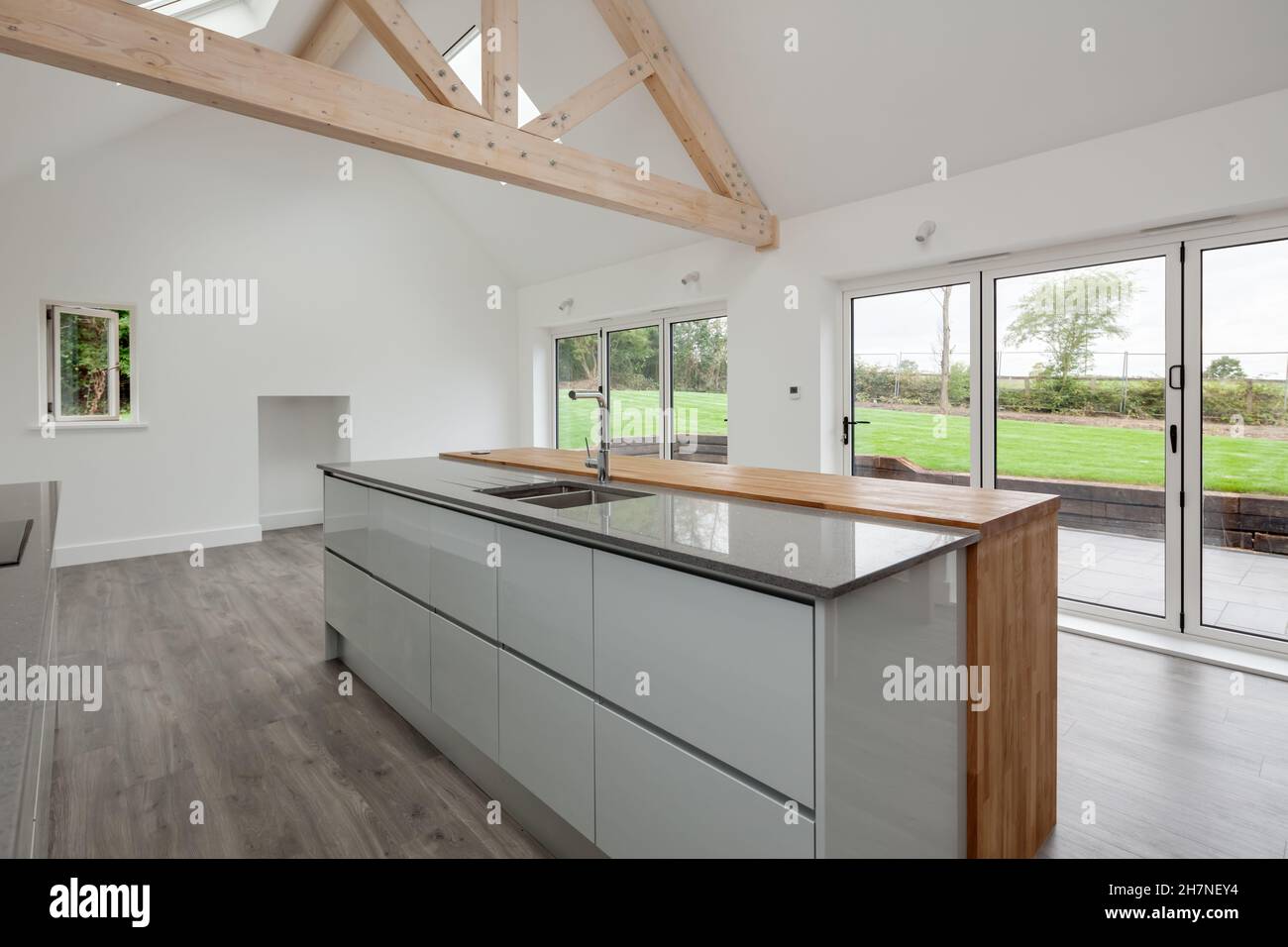 Lolworth, Cambridgeshire - July 30 2019: Brand new unoccupied home kitchen with vaulted ceiling and island peninsula unit Stock Photo