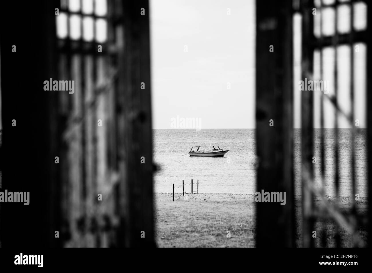 Black-white photography. Doors to alone boat in silent sea or ocean water Stock Photo