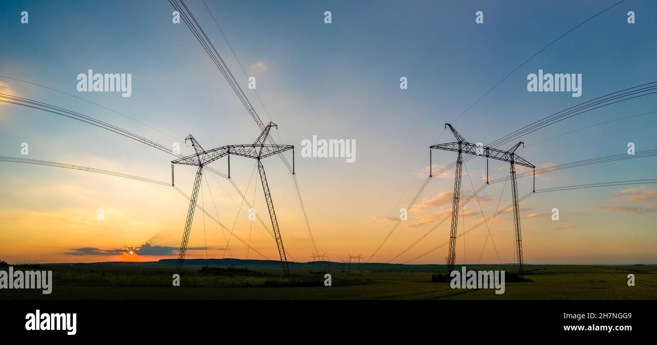 High voltage towers with electric power lines at sunset Stock Photo - Alamy
