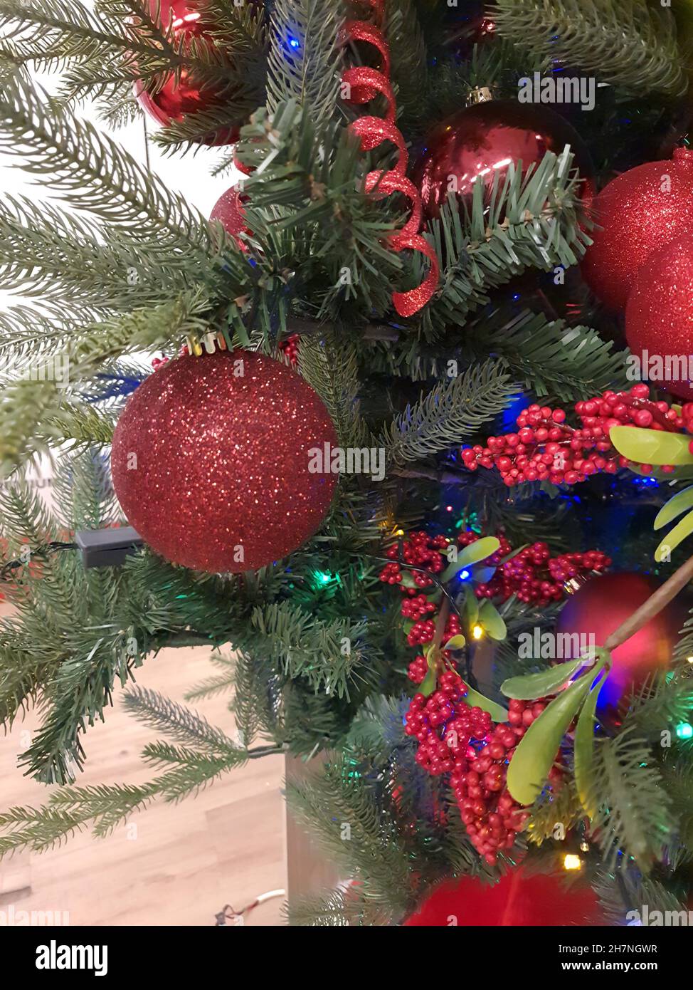 Christmas tree decorated with red baubles. Stock Photo