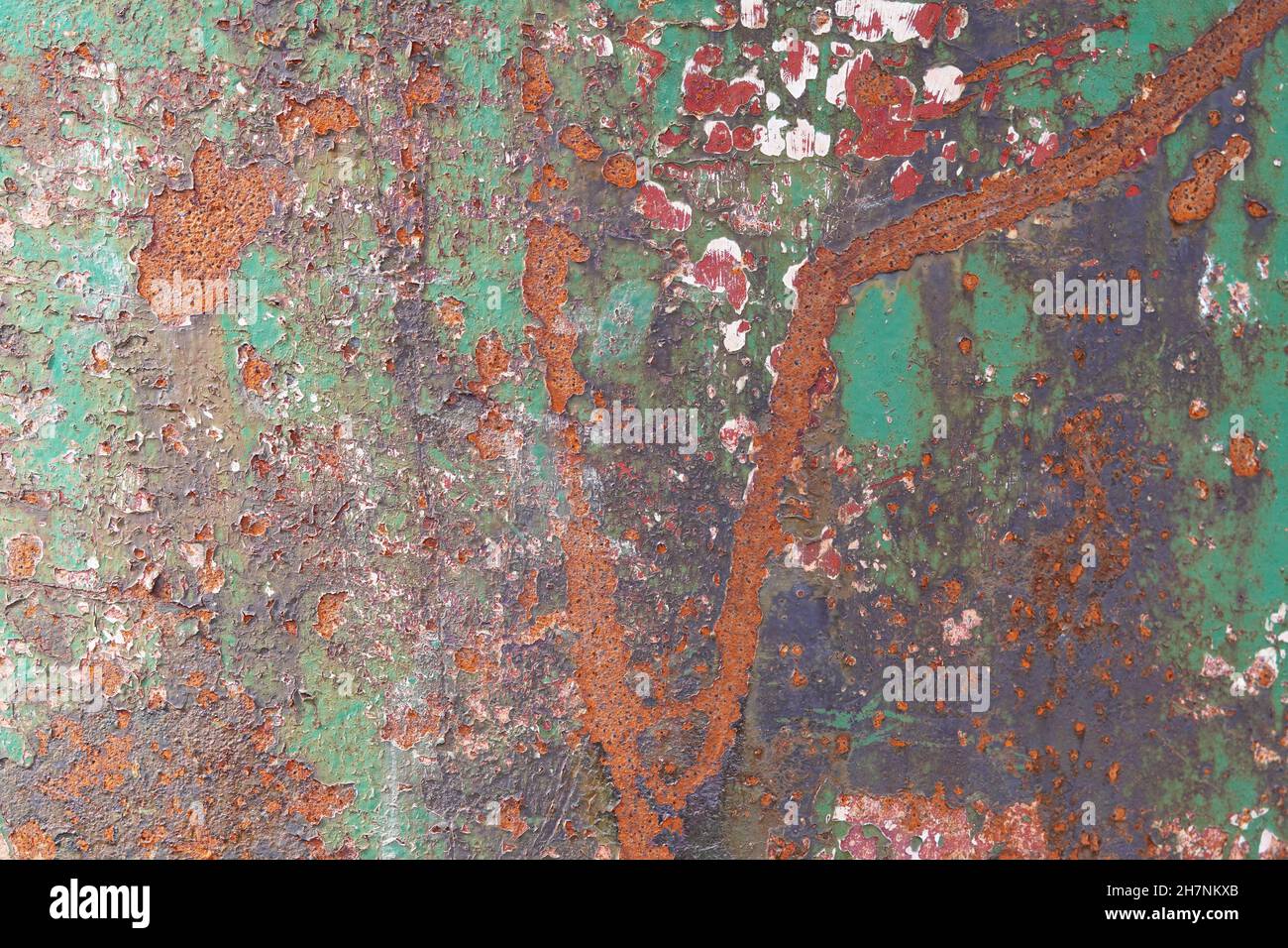 Rusted metal wall with layers of peeling paint. Backgrounds and textures. Stock Photo