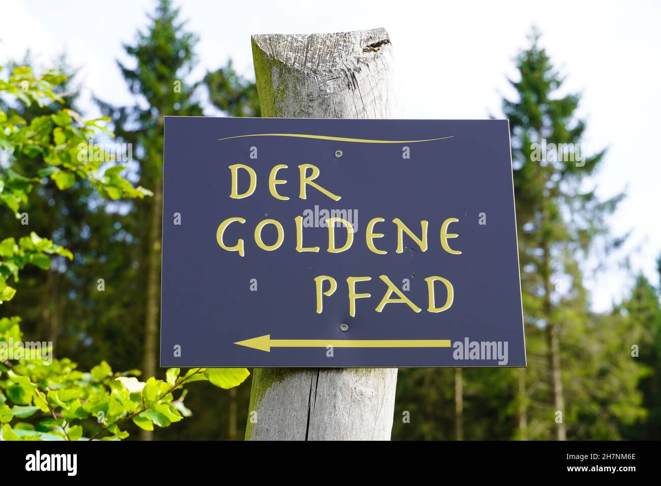 Shield in nature. Signpost on a hiking trail in the Sauerland. The golden path. Stock Photo