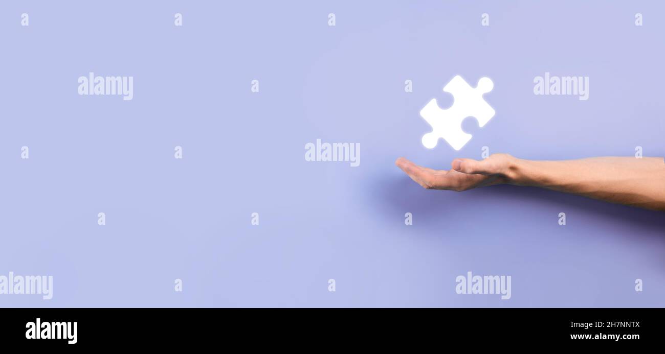 Businessman hands connecting puzzle pieces representing the merging of two companies or joint venture, partnership, Mergers and acquisition concept Stock Photo