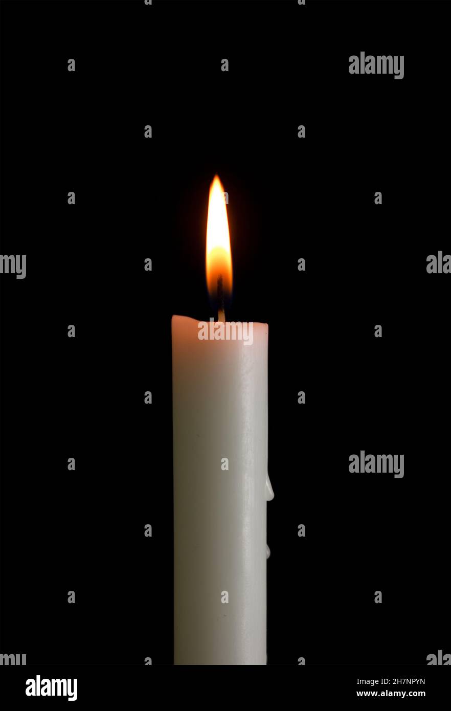 One candle with light isolated on a black background. Stock Photo