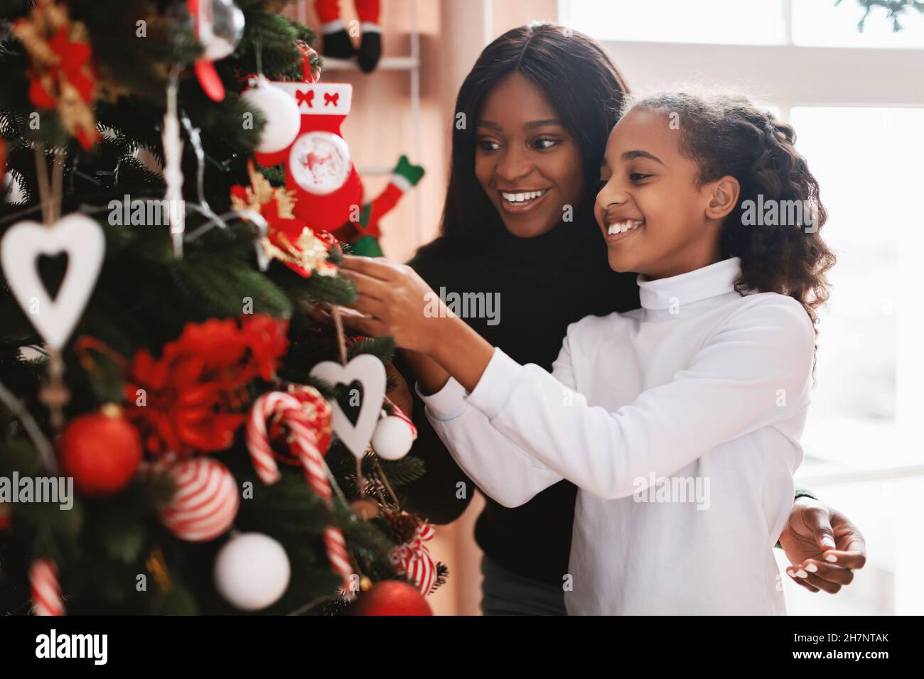 Portrait of happy black family decorating Xmas tree Stock Photo