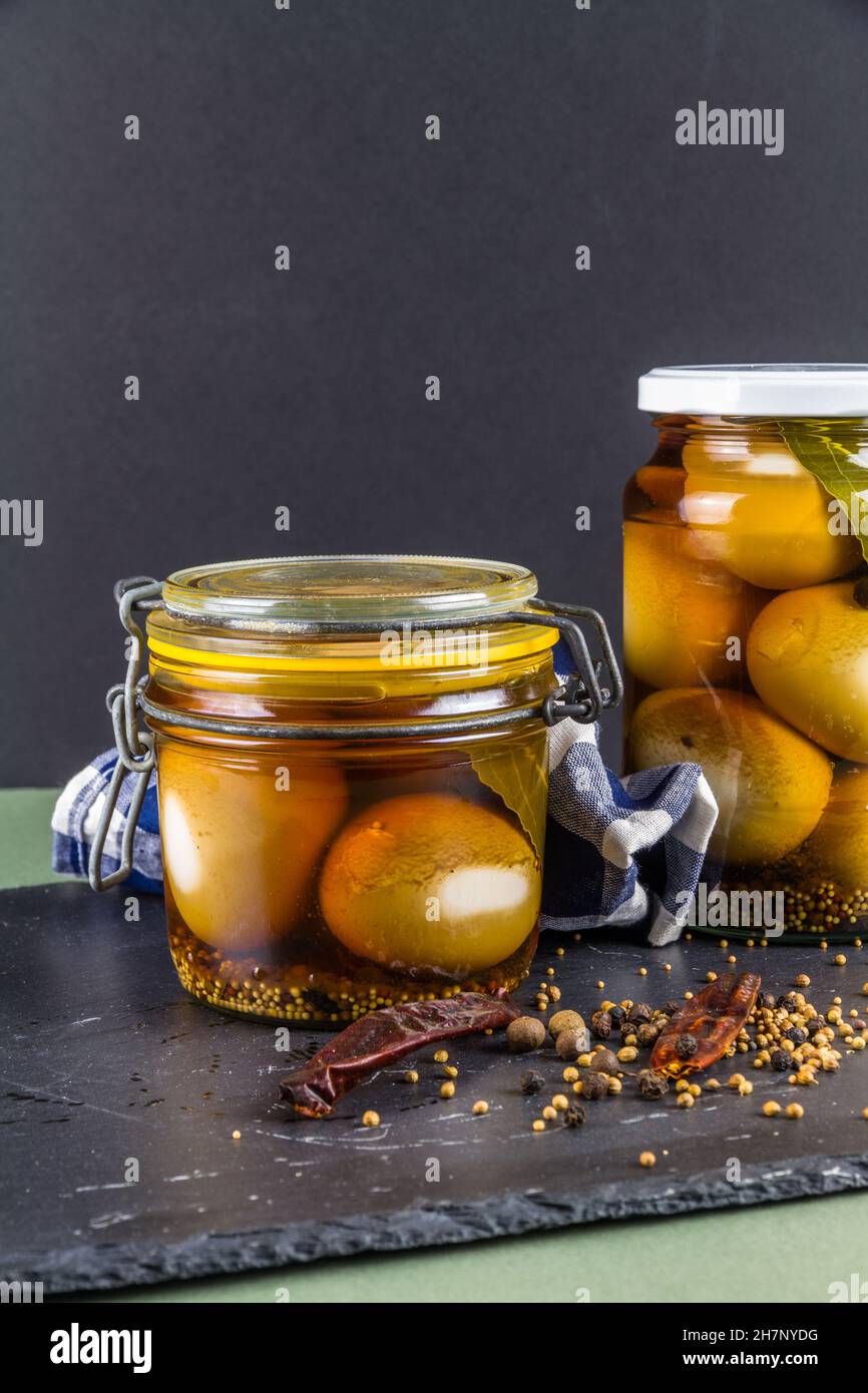 Two jars of eggs pickled in dark malt vinegar, portrait with copyspace