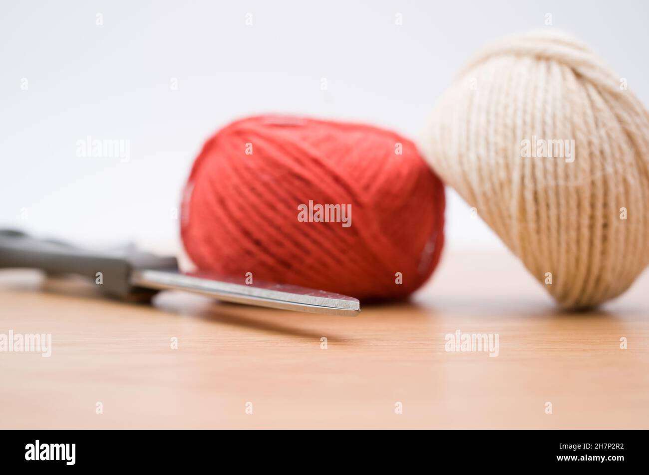 decorative rustic yarn ball and scissors on a wooden tabletop with copy ...