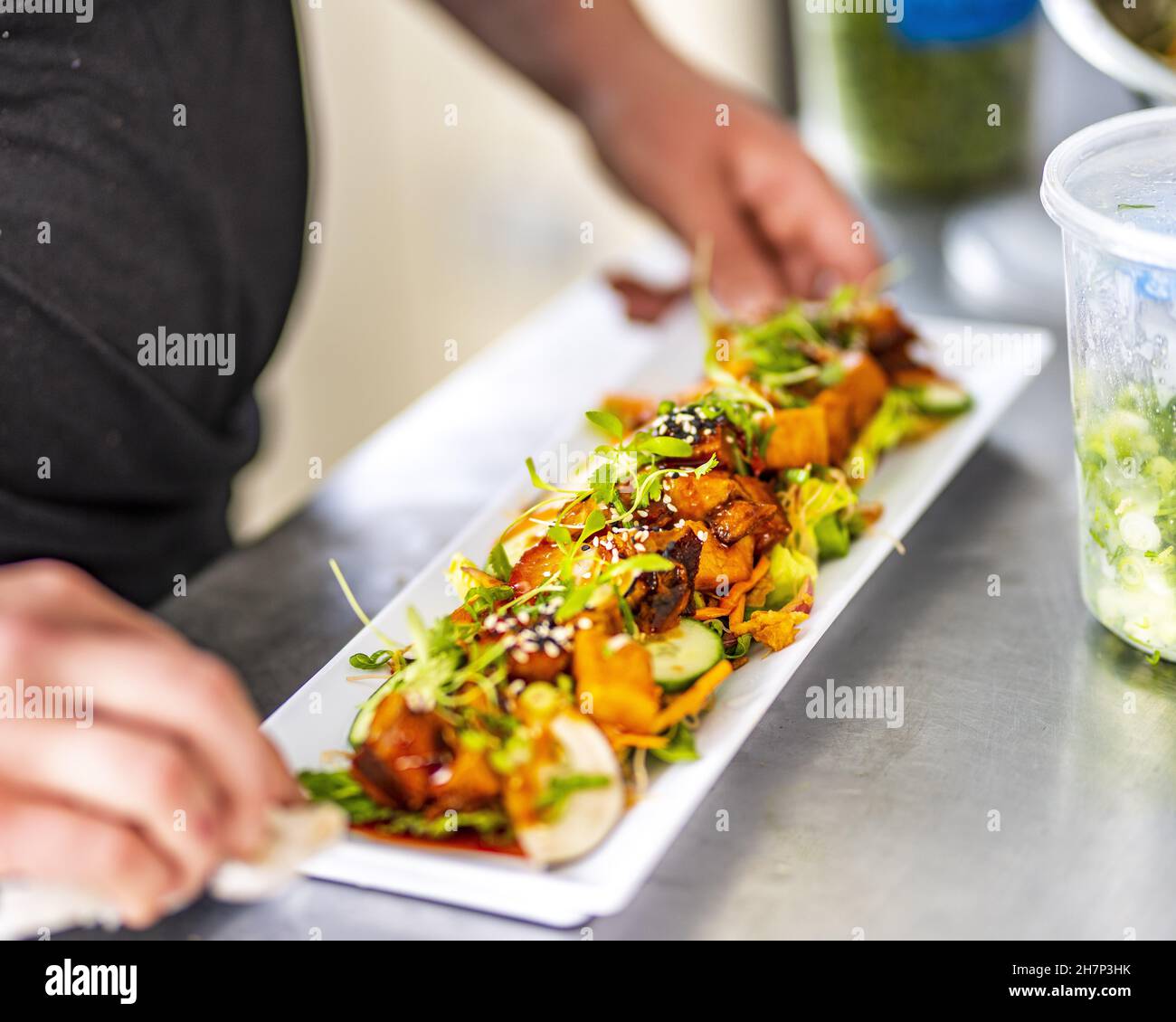 Chef wiping plate so that it can be served to eager guest Stock Photo