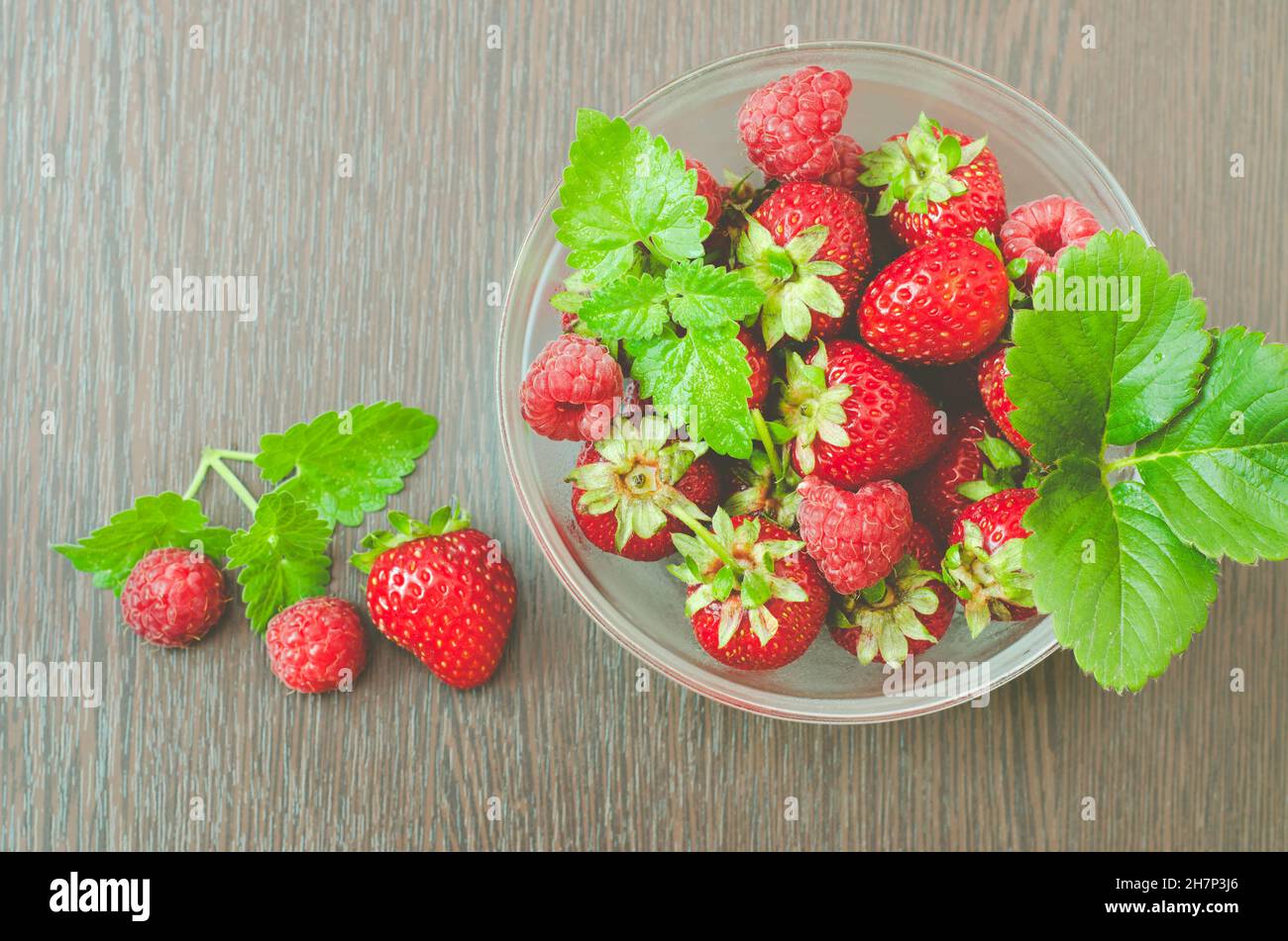 Top view of a bowl of strawberries and raspberries with mint leaves in ...
