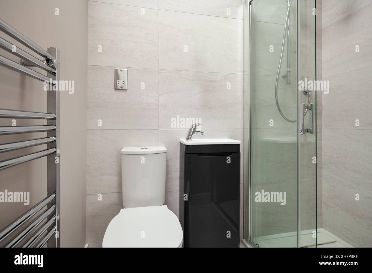 Compact shower room with toilet, wash basin and towel rail Stock Photo