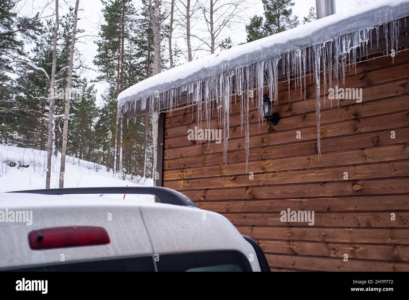 Icicles hang on a house roof. Snow melt from house roof warm winter day  27015686 Stock Photo at Vecteezy