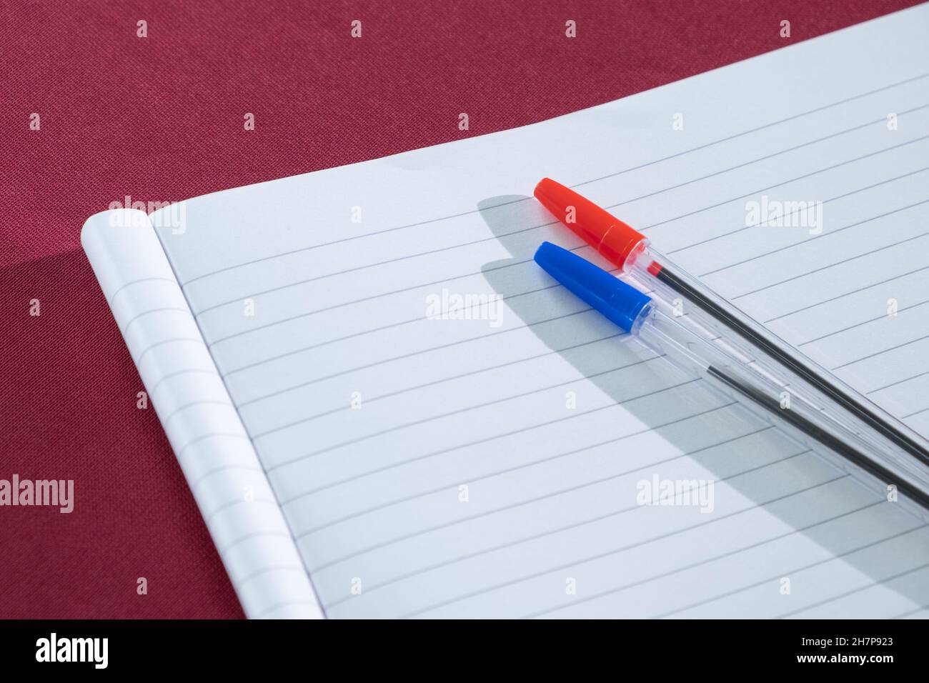 writing equipment blue and ren ballpoint pens placed on the lined paper Clean sheet of notebook for school notes Stock Photo