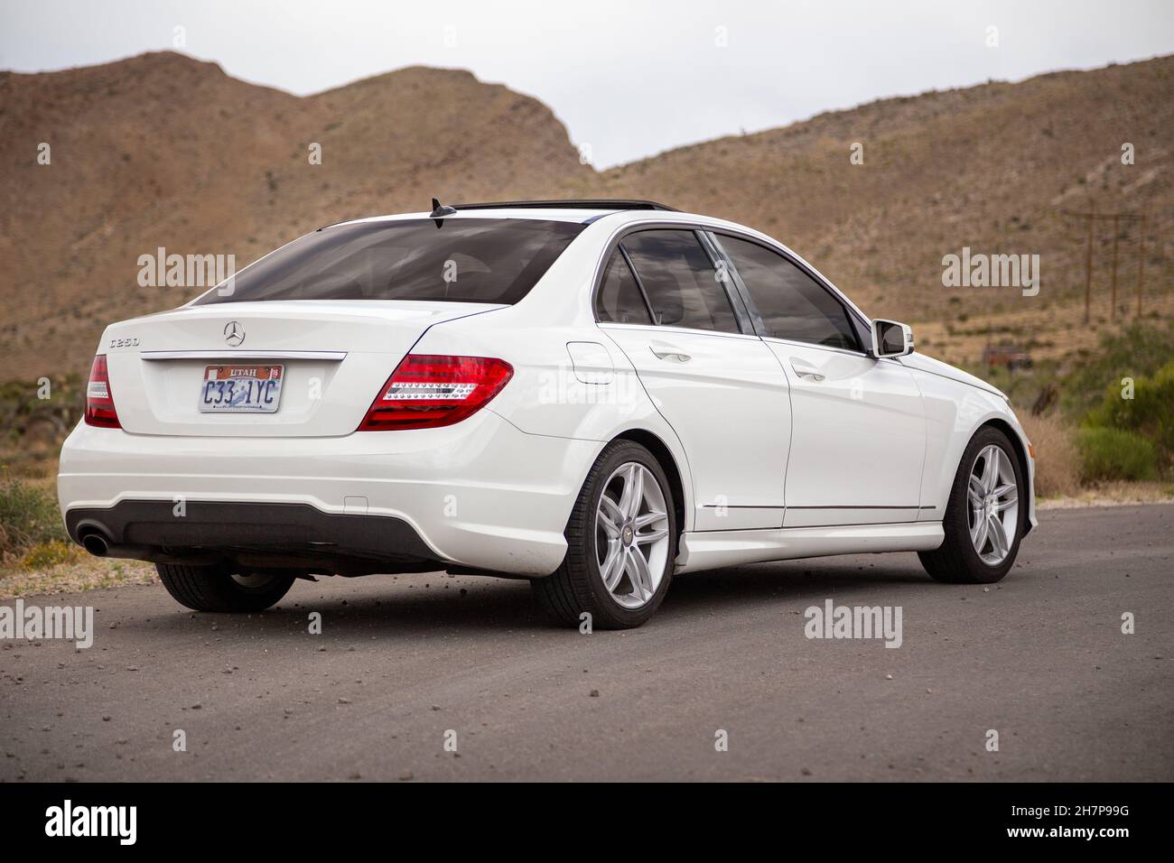 LAS VEGAS, UNITED STATES - May 22, 2015: Rear view of white 2014 Mercedes-Benz C-Class, a small luxury sedan, in the desert landscape of Nevada, USA. Stock Photo