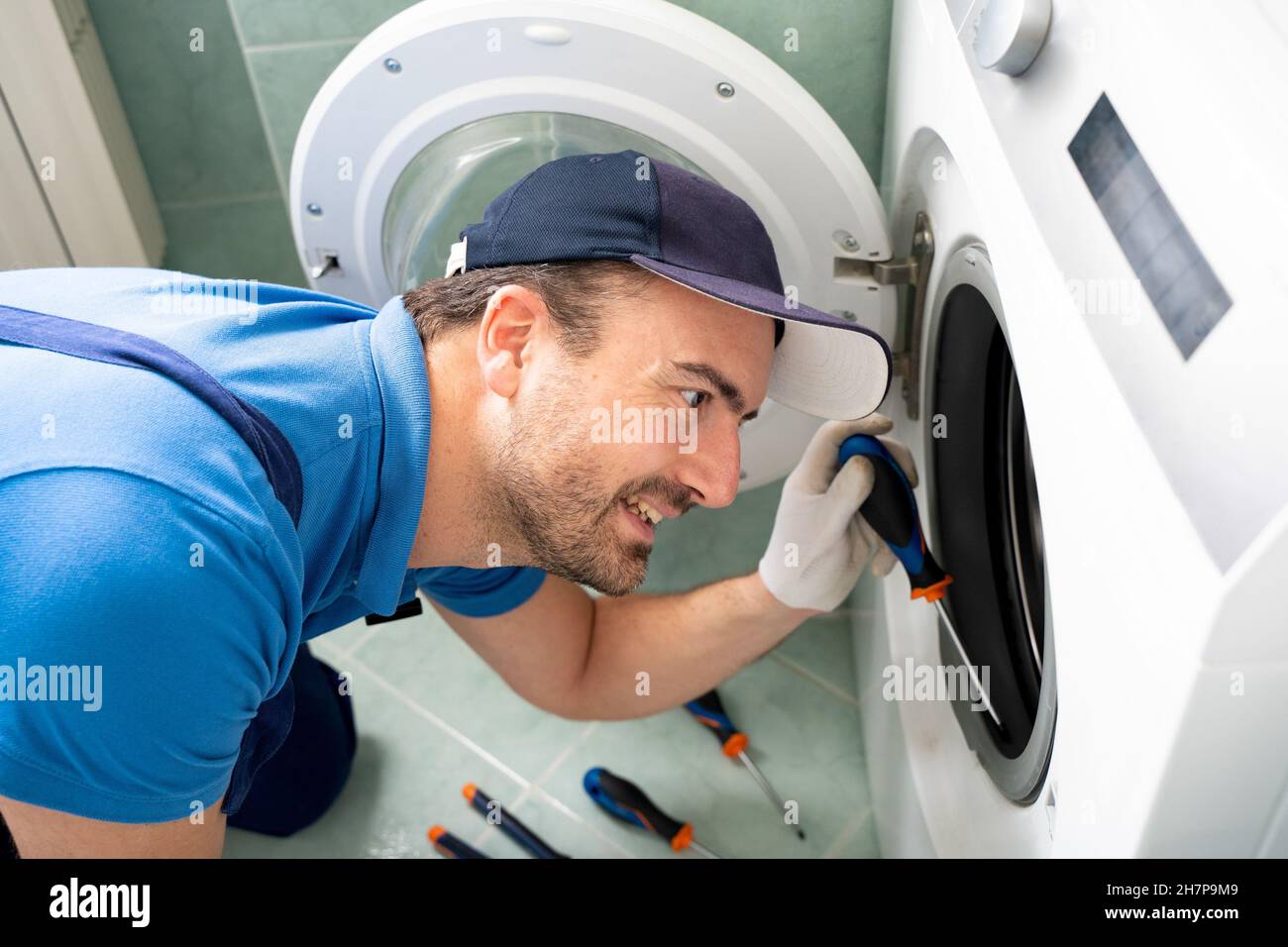 One expert repairman fixing a broken washing machine Stock Photo Alamy