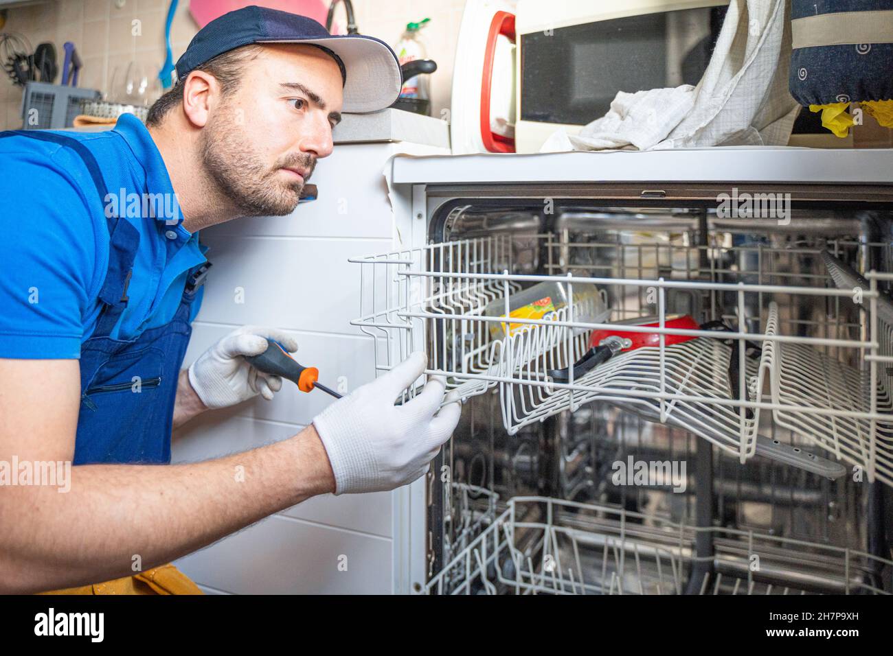 One repairman fixing malfunctioning kitchen dishwasher problem Stock