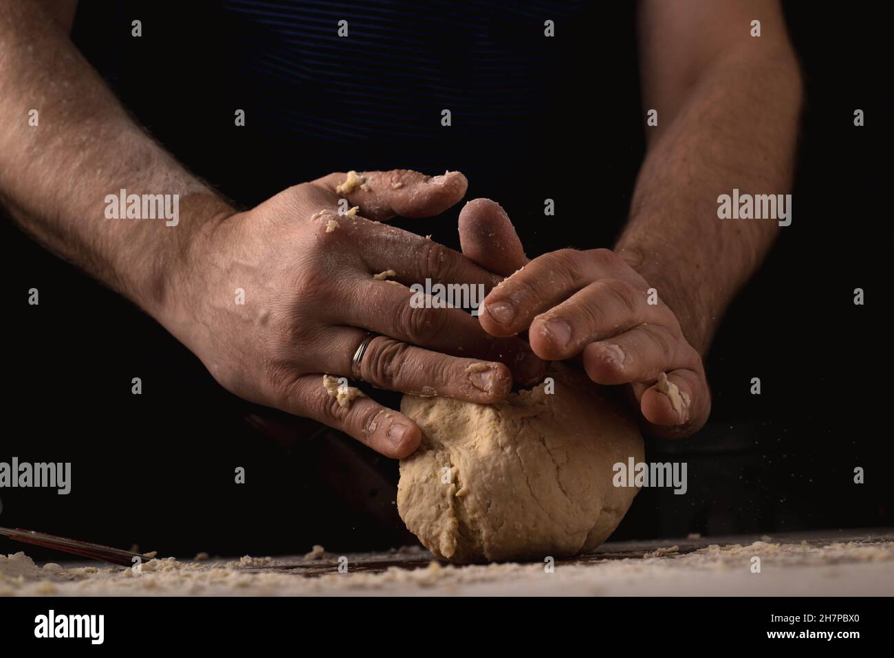 Male hands are making dough on a dark background Stock Photo - Alamy