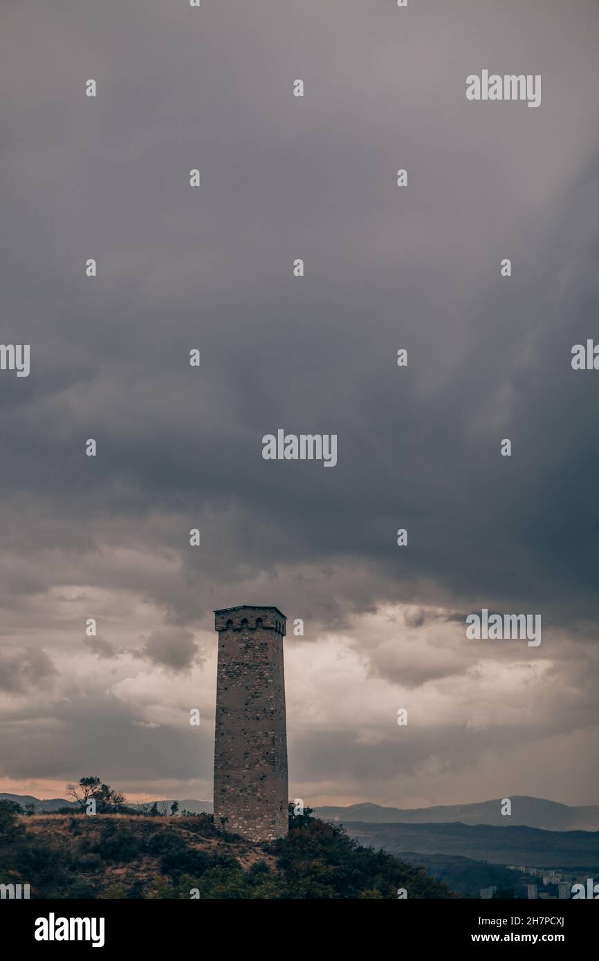 Large ancient stone tower stands on a hill in the forest. Mountain view ...