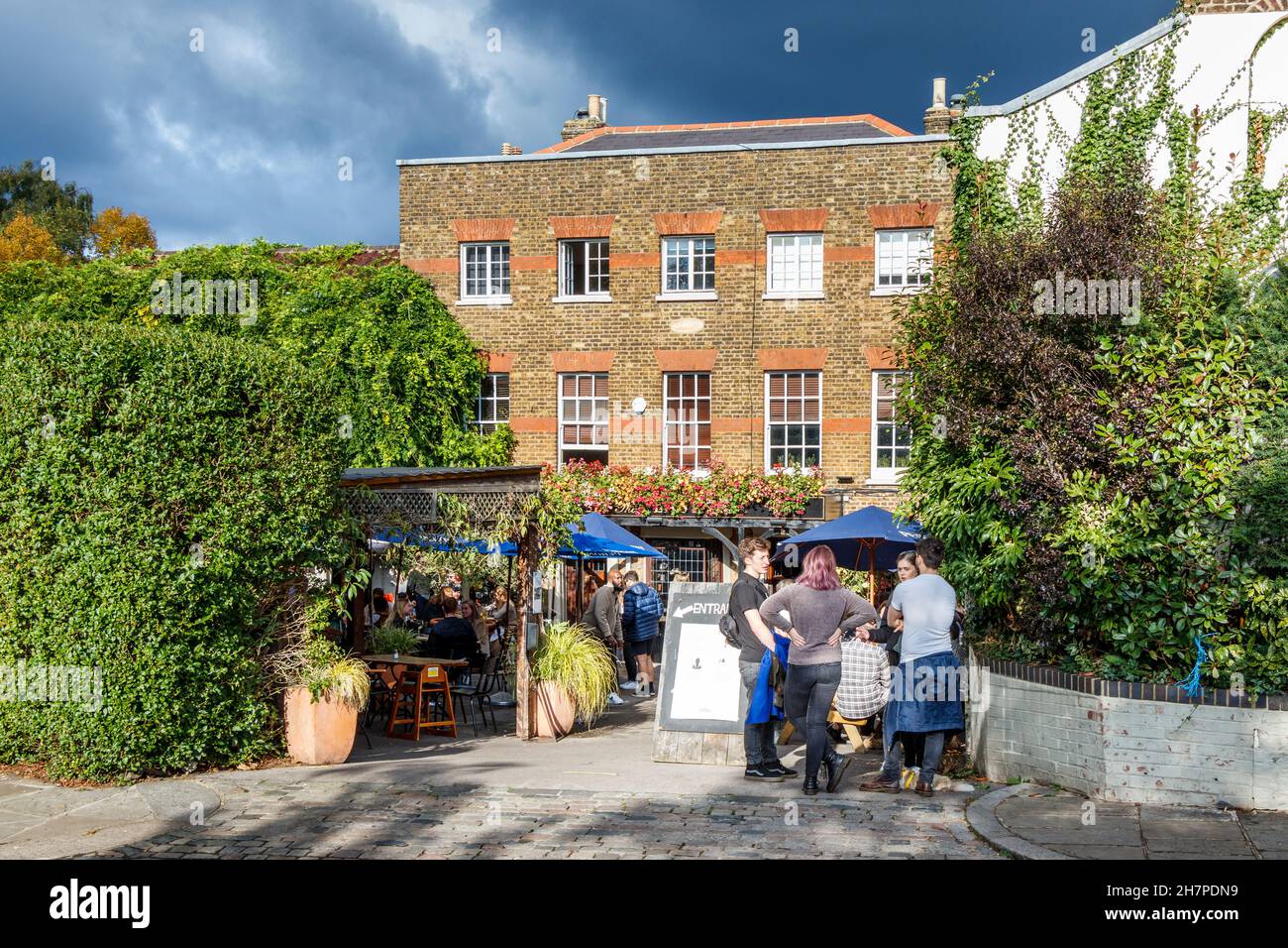 Drinkers in the beer garden of The Flask, a traditional pub in Highgate Village, London, UK Stock Photo