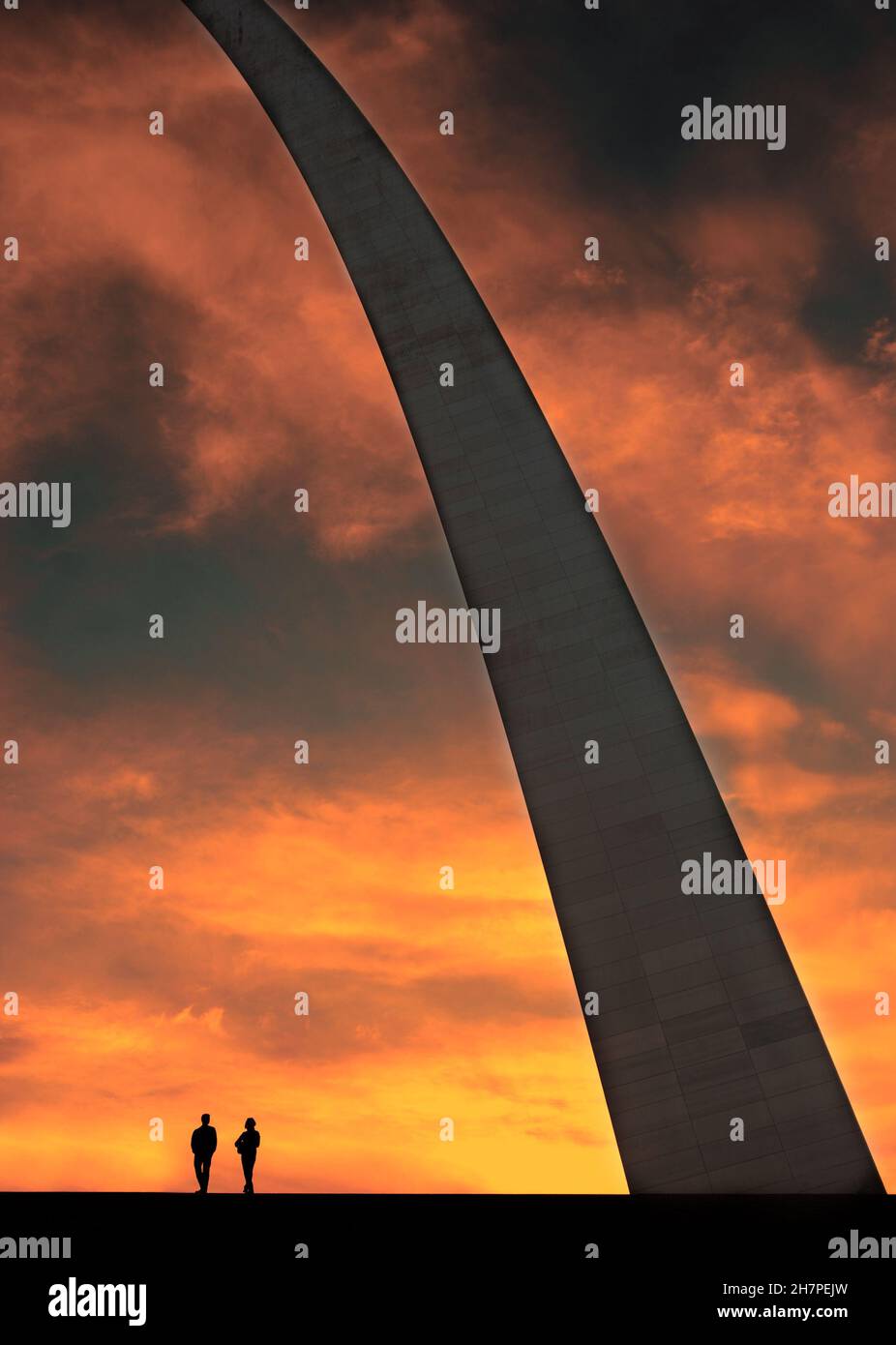 St Louis Arch landmark metal gateway at sunset with people a couple ...