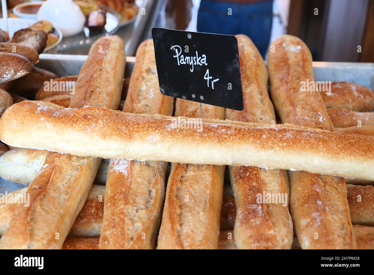 Artisanal bakery products in Poland. Parisian baguette (Paryska on tag means Parisian in Polish language). Stock Photo