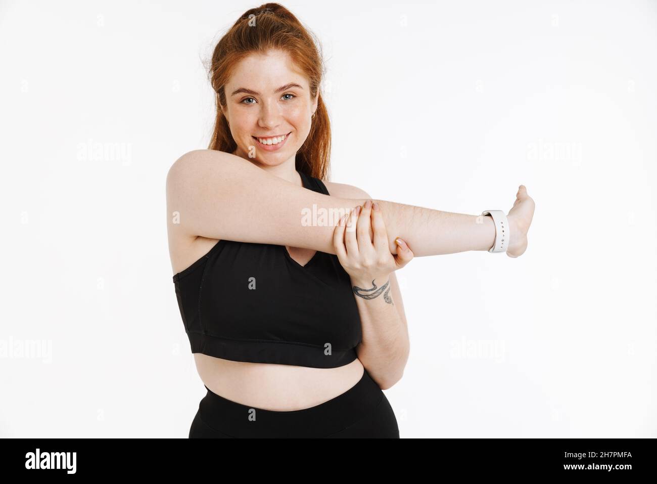 Stretch Routine For Plus Size Smiling young plus size fitness woman in sportswear standing over white ...