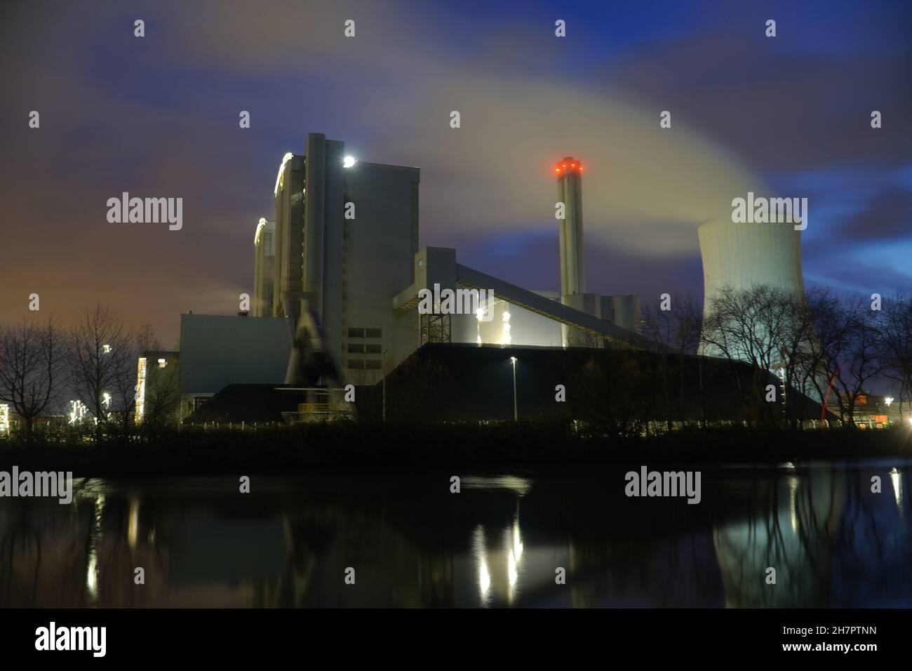 Coal-fired power plant with stone coal stockpile by night. Old technology that is one of the factors causing global warming. Hanover, Germany Stock Photo