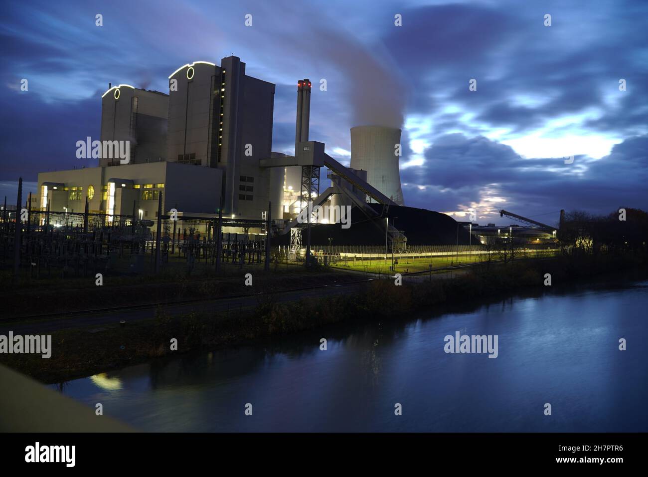 Coal-fired power plant with stone coal stockpile by night. Old technology that is one of the factors causing global warming. Hanover, Germany Stock Photo