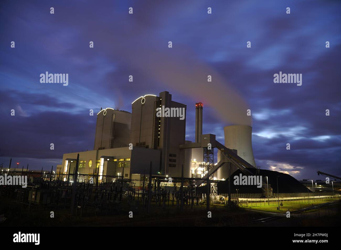 Coal-fired power plant with stone coal stockpile by night. Old technology that is one of the factors causing global warming. Hanover, Germany Stock Photo