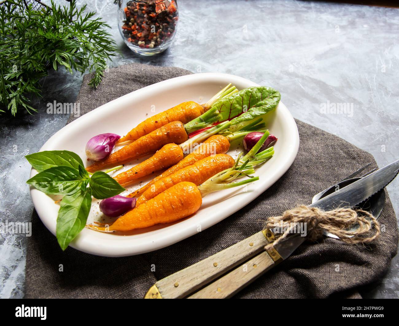 baked roast  baby carrots in a plate, basil and spices Stock Photo