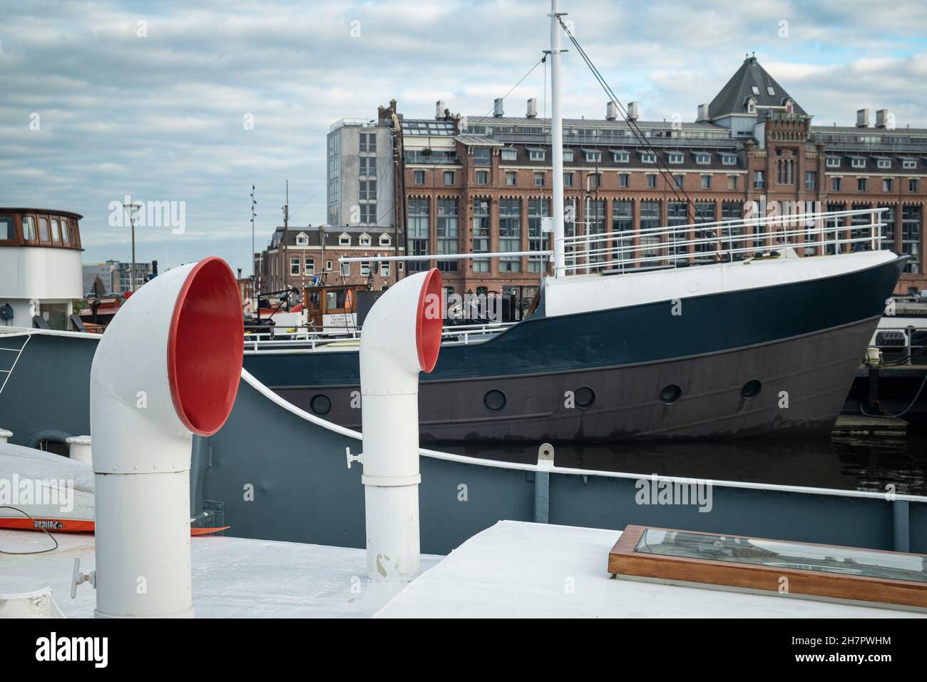 Ventilation intakes on the roof of a houseboat with The Silodam building in the background, Western Harbour, Amsterdam Stock Photo