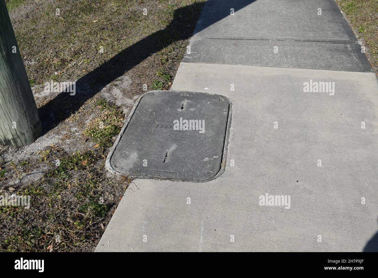 A concrete Fiber Optic cover in a sidewalk Stock Photo Alamy