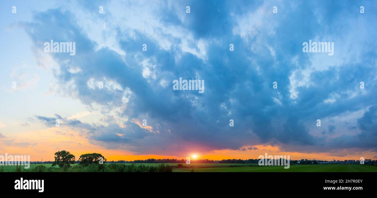 Panorama of rural landscape, sky in dark clouds dramatic bright sunset ...