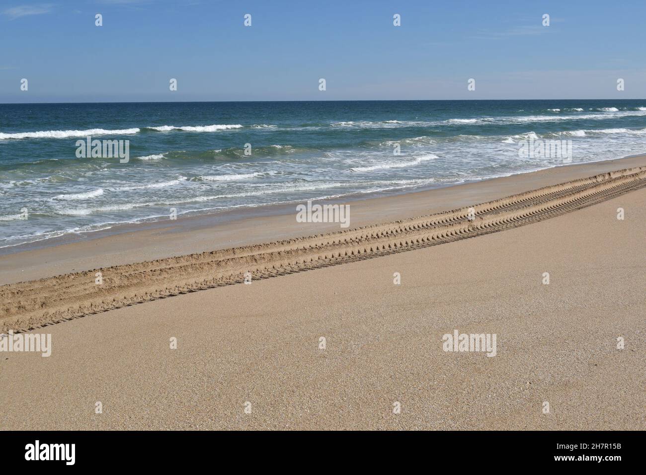 The only tracks on the beach today were made by a large vehicle. Stock Photo