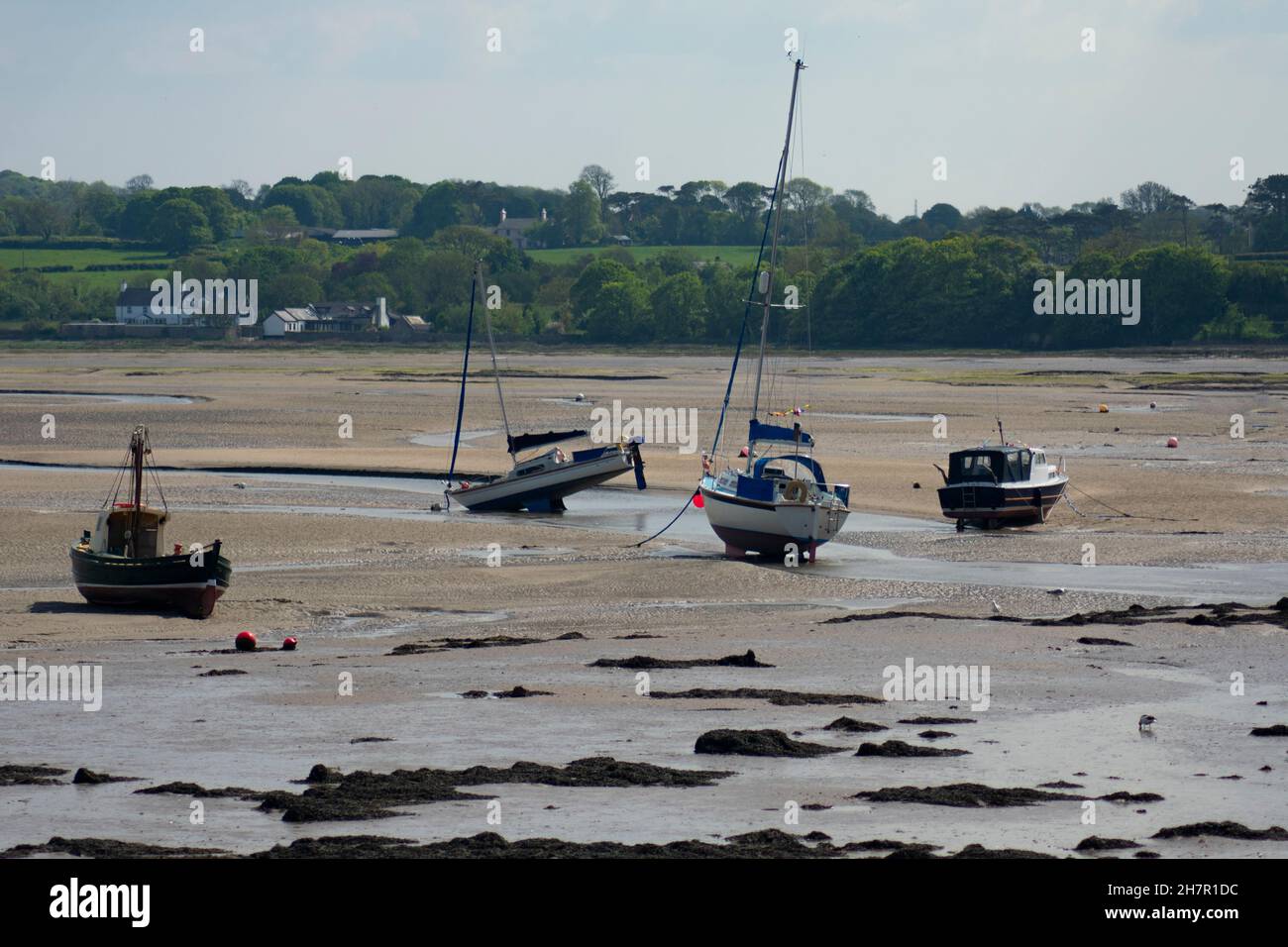 Red Wharf Bay, Anglesey, Wales. Pleasure boats at low tide on the sand flats of this beautiful destination.  Landscape aspect shot with copy space. Stock Photo