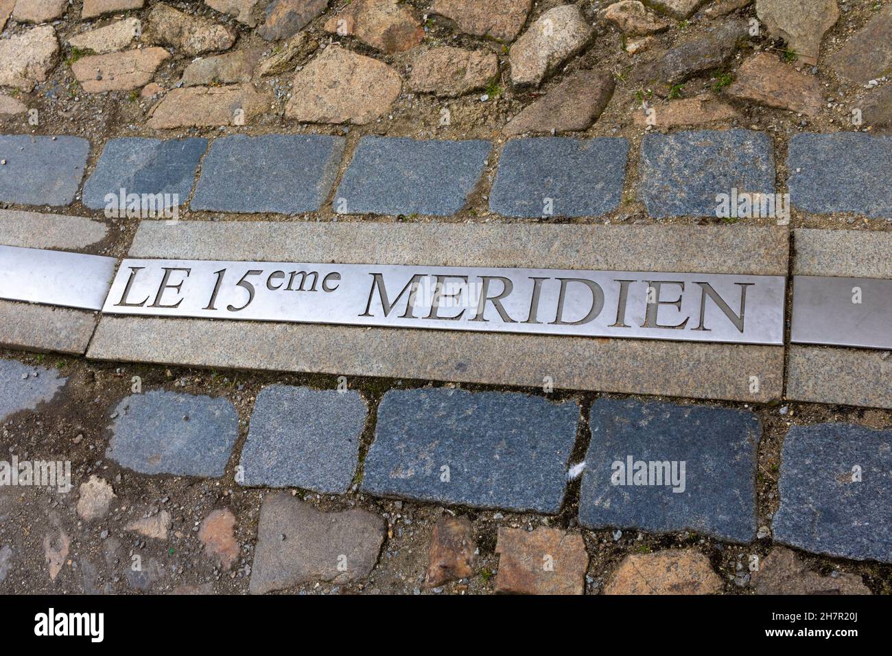 marker embedded in street pavement for the 15th meridian (Text in french translation) east longitude in the Czech town of jindrichuv Hradec. Stock Photo