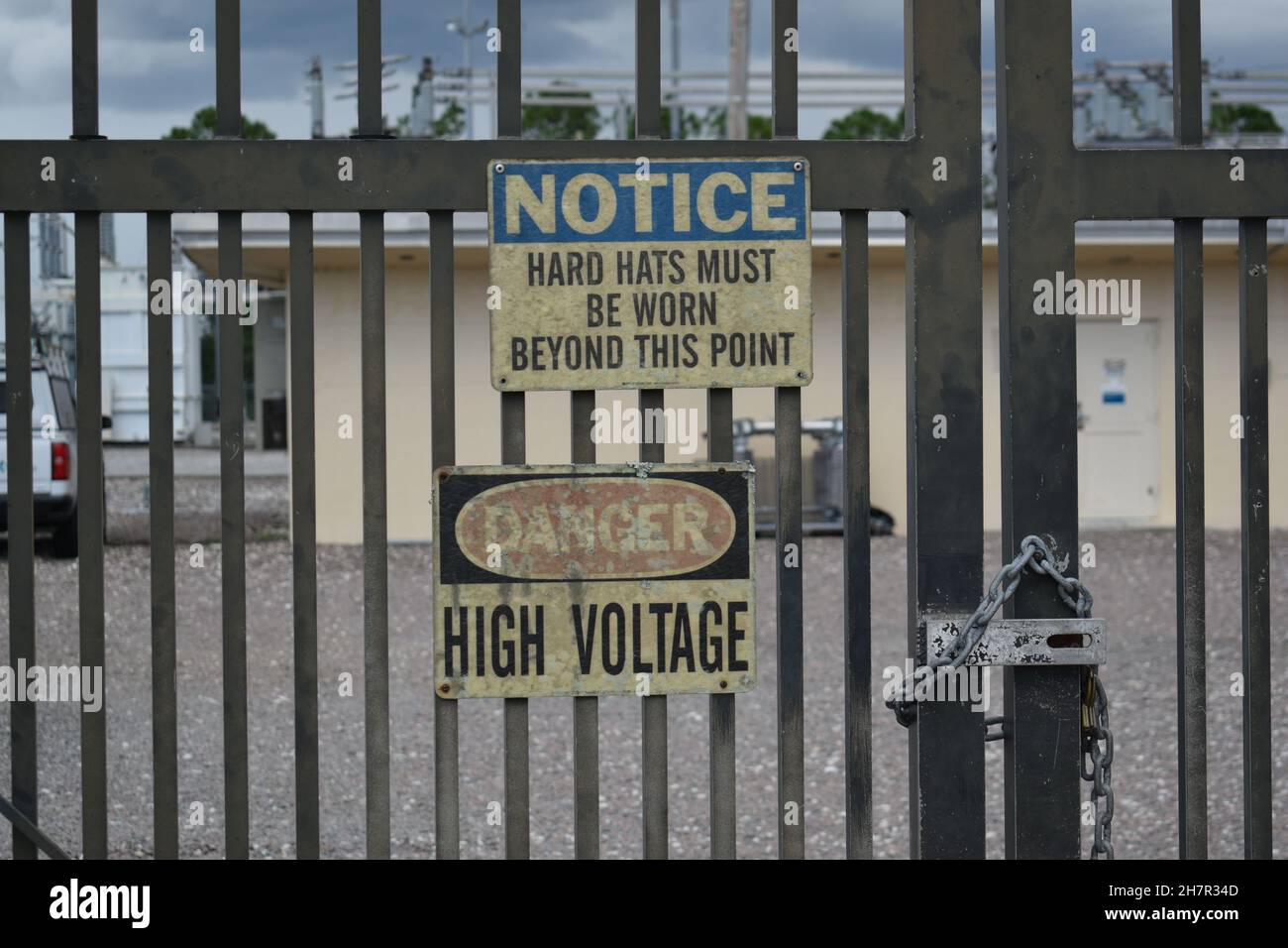 Warning signs are posted on the gate to a power substation. Stock Photo