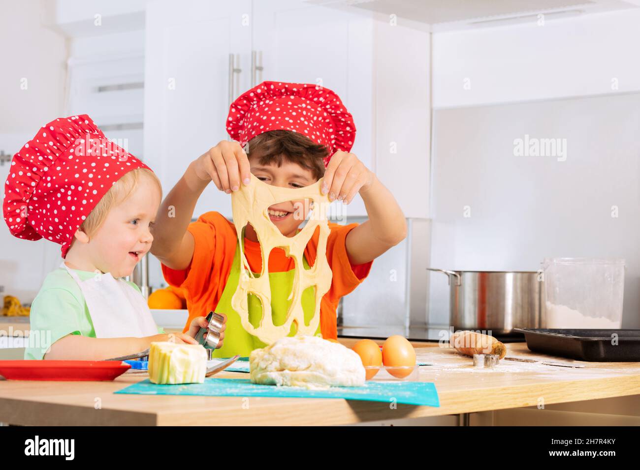 Happy kids play holding dough cutting out cookies Stock Photo